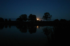 The moon rises over a calm Etang Bertie